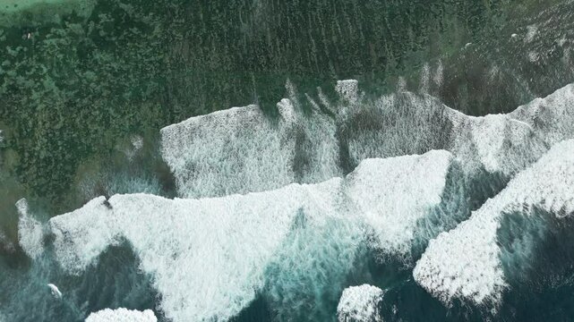 Blue Waves Crash Against The Rugged South Coast Of Uluwatu Bali Indonsia Asia Birdseye Drone 4K 60FPS