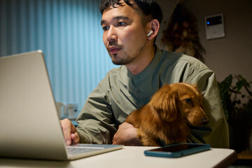 リモートワーク中の男性と犬