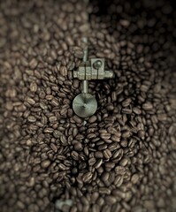 Coffee Beans in Roasting Machine with Metal Paddle. Close-up view of roasted coffee beans with a metal stirring arm inside a coffee roaster. Rich texture and deep tones of freshly roasted beans