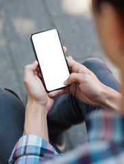 Person holding a modern smartphone with a blank white screen outdoors