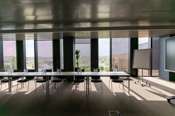 This spacious conference room, with large windows for natural light, creates a bright atmosphere...