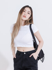 Fashionable photo concept confident woman model asian beautiful female wearing trendy white top shirt black cargo pants casual outfits standing posing look at camera in studio on colorful background.