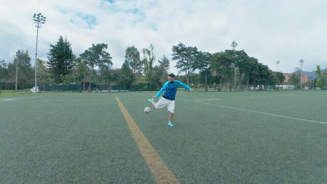 Friends practicing soccer in outdoors soccer field, passing ball. Rear point of view.
