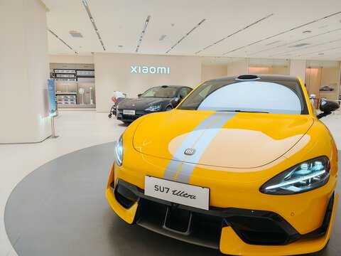Jun 23, 2025 - China: Xiaomi SU7 Ultra electric car displayed in showroom, vibrant yellow.