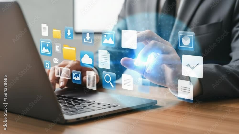 Poster person using laptop with digital icons hovering above the keyboard on a wooden surface top view