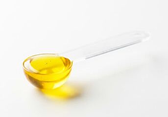 Golden Liquid Supplement A Close-Up View of a Measuring Spoon Filled with Yellow Oil