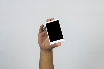 Hand holding photo frame isolated on white background.