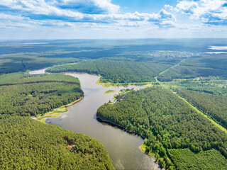 Aerial view of lake or river green shore with forest. Summer season.
