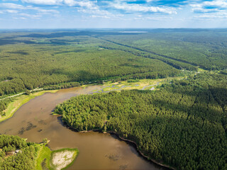 Aerial view of lake or river green shore with forest. Summer season.