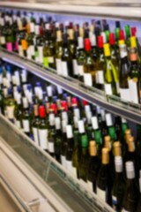 Variety of wine bottles arranged on shelves in supermarket