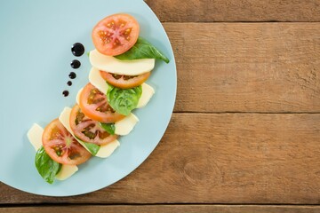 Fresh salad in plate on wooden table
