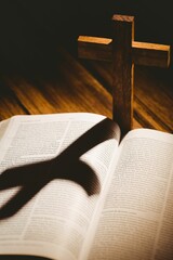 Wooden cross with shadow on bible