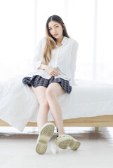 Asian young happy beautiful woman relaxes in sunlight enjoying peaceful moment sitting posing on...