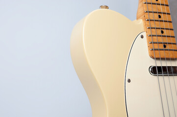 Six-string electric guitar, with a cream-colored wooden body and chrome-plated fittings.