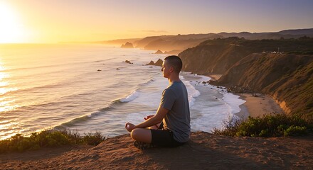 Man meditating on a coastal cliff at sunset.