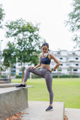 A young slim athletic asian girl in sportswear with snakeskin prints performs a set of exercises....