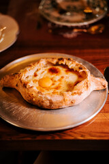 Traditional Adjarian khachapuri served fresh in a cozy Georgian restaurant