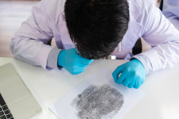 Forensic fingerprint analysis, criminalist collects latent fingerprints using fingerprint powder on...