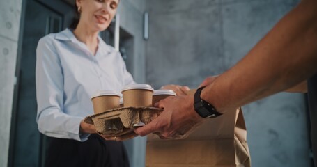 Delivery Man Brining Coffee and Restaurant Food in Paper Bag for Businesswoman Working in Modern Office Building. Happy Woman Taking Coffee and Lunch from Man. Food Delivery Service. Close Up Shot.