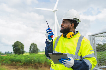 man in a yellow safety vest is holding a walkie talkie and a tablet