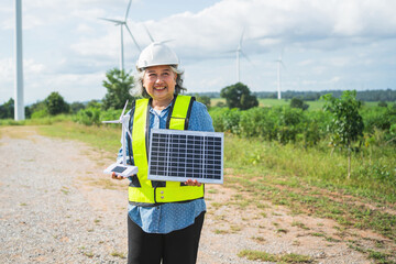 woman wearing a yellow vest holding a solar panel