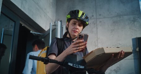 Delivery Woman Wearing Bicycle Helmet Standing near Office Building, Notifying Client about...