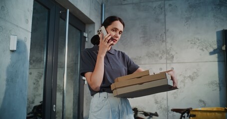 Delivery Woman Standing near Office Building with Pizza in Cardboard Boxes, Notifying Client by Phone about Successful Delivery. Woman Working in Pizza Delivery Service, Delivering Restaurant Food.