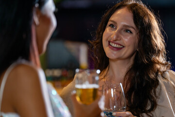 Two female friends enjoy a deep conversation over a glass of wine at a party or bar A concept for friendship social life and a girls night out