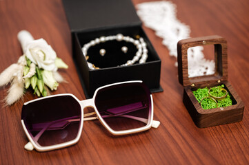 Wedding accessories: sunglasses, jewelry, and rings.