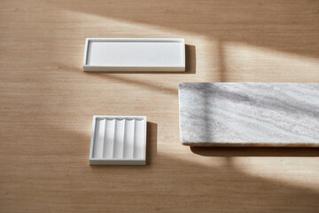 Light and Shadow on Wooden Texture with Modern Objects. Minimal Home Decor Scene with Ceramic Trays.
