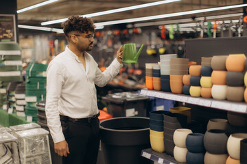 Man Shopping for a Watering Can in Garden Supplies Store
