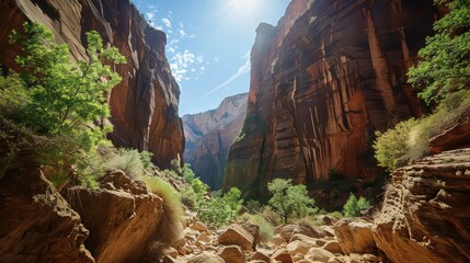 View of a canyon with rocky terrain and green vegetation under a bright blue sky with scattered clouds