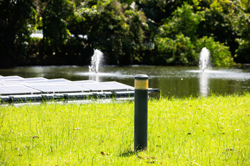Selective focus to metal black streen lamp standing with blurry Solar photovoltaic power station on...