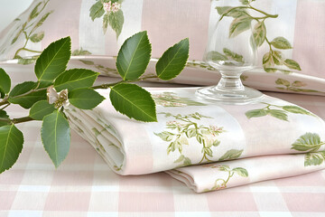Fresh Green Leaves and Floral Linen with Glassware on a Pink Che