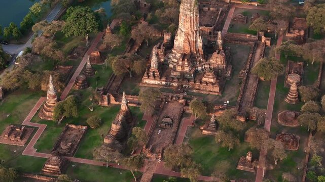 Close up cinematic tilt drone shot of the central prang and adjacent structures at Wat Phra Ram, highlighting intricate ancient architecture.