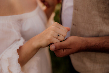 Couple holding hands, woman wearing dark gemstone engagement ring
