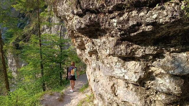 An individual navigates a narrow trail
