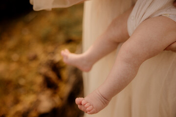 Close-up of baby legs and feet against soft beige fabric