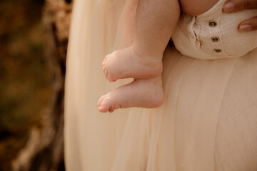 Close-up of baby legs and feet against soft beige fabric