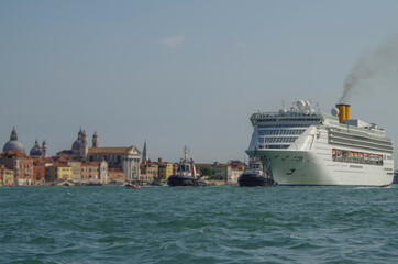 Italian luxury cruise ship Victoria cruising the Giudecca Canal with tug boats towards the cruise...