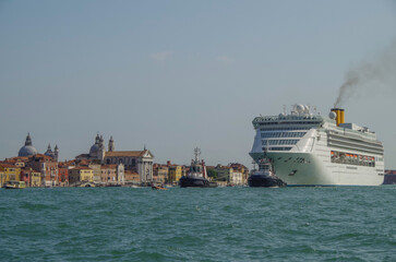 Italian luxury cruise ship Victoria cruising the Giudecca Canal with tug boats towards the cruise...