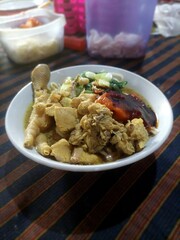 A Bowl of Delicious Chicken Noodles with Complete Toppings: Chicken Pieces, Dumplings, Meatballs, Green Mustard Greens, and Sprinkled with Spring Onions