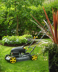 Brand new lawnmower in green garden, ready for work