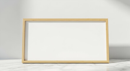 Empty light beige wooden picture frame on a marble surface, showcasing a blank white canvas.