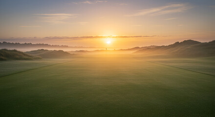 Sunrise over a golf course in morning mist