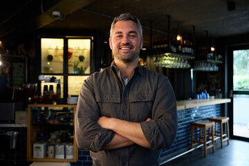 A Caucasian man standing with his arms crossed