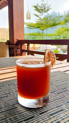 Iced Tea Herbal Drink with Dried Citrus Garnish in Tropical Outdoor Caf&eacute;