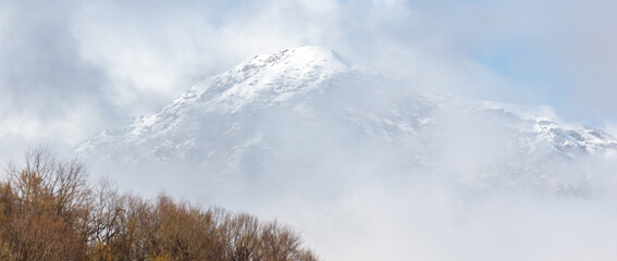A mountain covered in snow and fog
