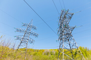 Two tall power lines are in the sky, one of which is taller than the other