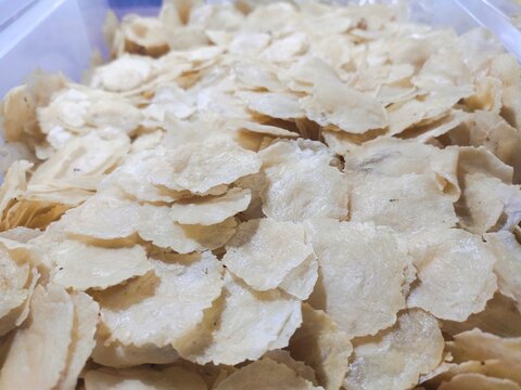 Pile of raw Emping melinjo, is typical Indonesian snack product made from ground dried melinjo or Gnetum gnemon seeds that have not been fried or processed further